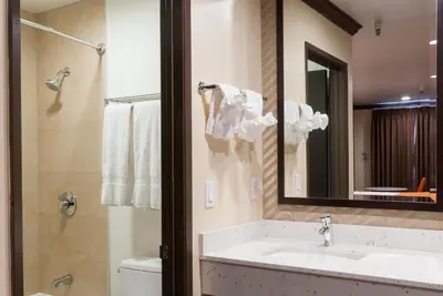 a bathroom with a sink and a mirror and a toilet at Redondo Pier Inn in Redondo Beach
