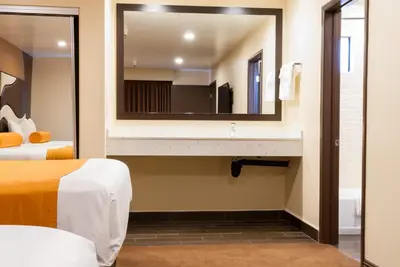 a bathroom with two beds and a mirror at Redondo Pier Inn in Redondo Beach