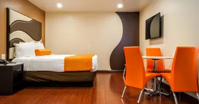 a hotel room with a bed and a table and chairs at Redondo Pier Inn in Redondo Beach