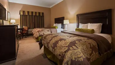 a hotel room with two beds and a television at Best Western Route 66 Glendora Inn in Glendora