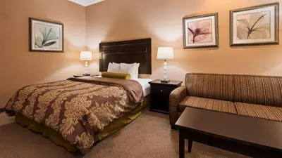 a hotel room with a bed and a couch at Best Western Route 66 Glendora Inn in Glendora