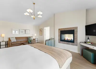 a white bedroom with a bed and a tv at Inn at Playa del Rey in Los Angeles