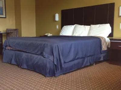 a large bed in a hotel room with a blue blanket at Del Amo Inn in Torrance