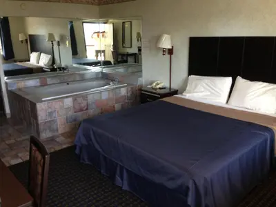 a hotel room with a bed and a bath tub at Del Amo Inn in Torrance