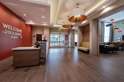 a lobby of a hotel with a welcome to the golden store at Hampton Inn & Suites Buena Park in Buena Park