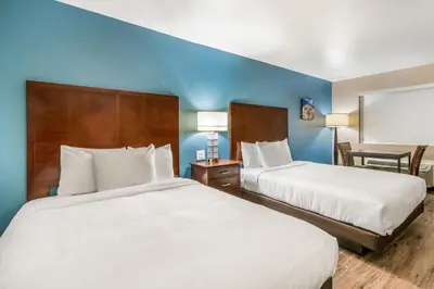two beds in a hotel room with blue walls at Hotel Hacienda at Ontario Ranch in Ontario