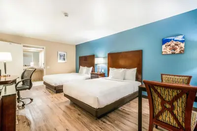a hotel room with two beds and a desk at Hotel Hacienda at Ontario Ranch in Ontario