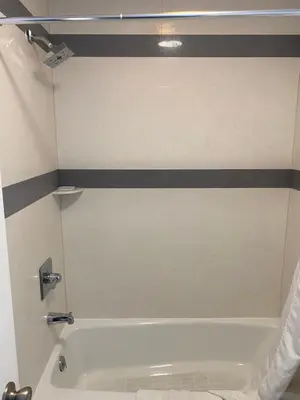 a bathroom with a white tub and a black and white stripes at Golden West Manor Motel in Los Angeles