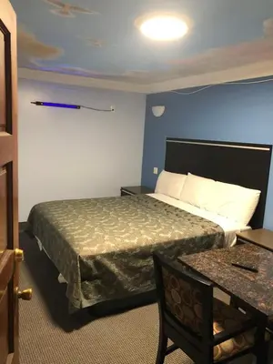 a hotel room with a bed and a table at Golden West Manor Motel in Los Angeles