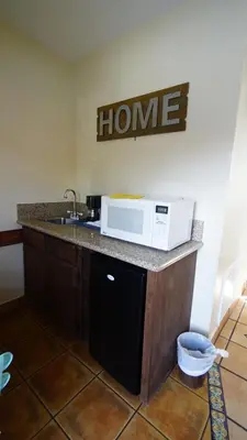 a kitchen with a sink and a microwave on a counter at Villa Brasil Motel in Los Angeles