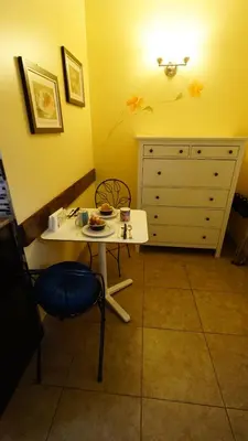 a small table and chair in a room with a dresser at Villa Brasil Motel in Los Angeles