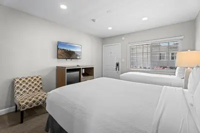 a bedroom with a bed and a desk and a chair at Ocean Park Inn in Los Angeles