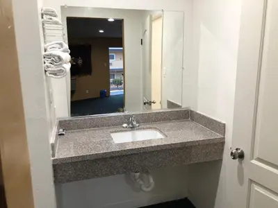 a bathroom with a sink and a mirror at Los Angeles Inn & Suites - LAX in Los Angeles