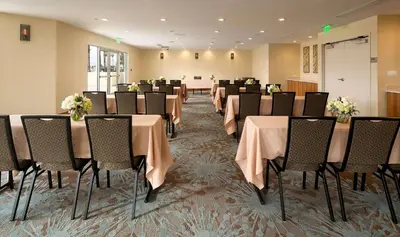a conference room with tables and chairs with flowers on them at Redondo Beach Hotel, Tapestry Collection by Hilton in Redondo Beach