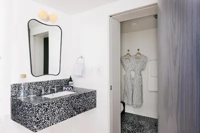 a bathroom with a black and white sink and a mirror at Short Stories Hotel Near The Grove in Los Angeles