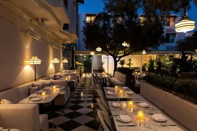 a restaurant with tables and chairs on a patio at night at Short Stories Hotel Near The Grove in Los Angeles