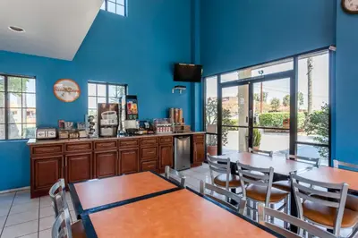 a restaurant with blue walls and tables and chairs at Howard Johnson by Wyndham Norco in Norco