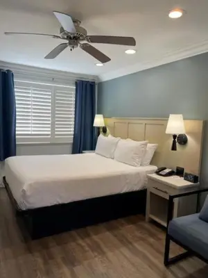 a bedroom with a bed and a ceiling fan at Ramada by Wyndham Redondo Beach in Redondo Beach