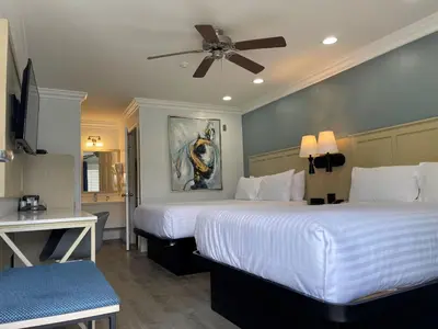 a hotel room with two beds and a ceiling fan at Ramada by Wyndham Redondo Beach in Redondo Beach