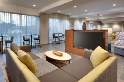 a living room with a couch and a flat screen tv at Courtyard by Marriott Los Angeles LAX/Hawthorne in Hawthorne