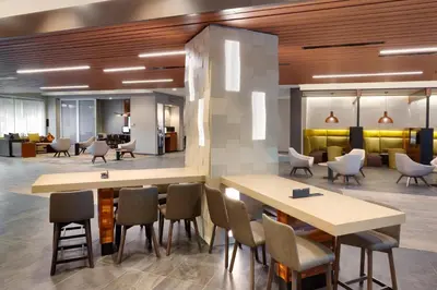 a lobby with tables and chairs in a building at Courtyard by Marriott Los Angeles LAX/Hawthorne in Hawthorne