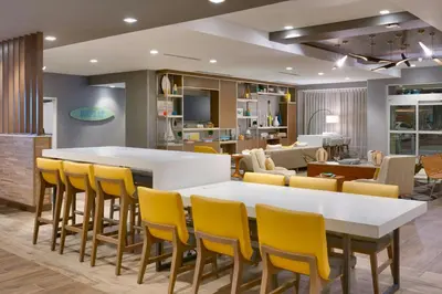 a living room with a white table and yellow chairs at TownePlace Suites by Marriott Los Angeles LAX/Hawthorne in Hawthorne