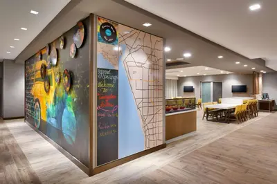 an office lobby with a large wall of art at TownePlace Suites by Marriott Los Angeles LAX/Hawthorne in Hawthorne