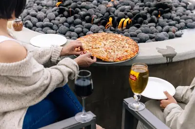 a group of people sitting around a table with a pizza at TownePlace Suites by Marriott Los Angeles LAX/Hawthorne in Hawthorne