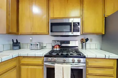 a kitchen with a stove and a microwave at Victoria Court Vacation in Lake Arrowhead