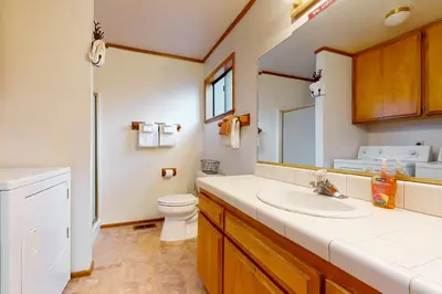 a bathroom with a sink and a toilet and a mirror at Victoria Court Vacation in Lake Arrowhead