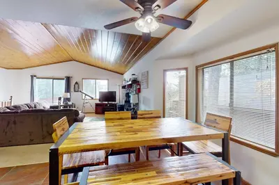 a dining room with a table and a ceiling fan at Victoria Court Vacation in Lake Arrowhead