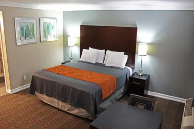 a hotel room with a bed with an orange blanket at Friendly Hills Inn - Whittier, Los Angeles in Whittier