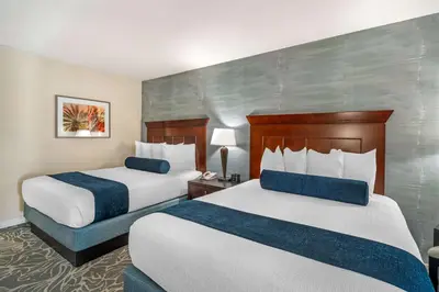 a hotel room with two beds with blue accents at Best Western Plus Carpinteria Inn in Carpinteria