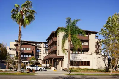 a building with two palm trees in front of it at Ambrose Hotel in Los Angeles