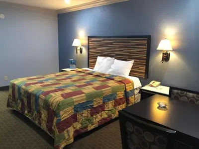 a hotel room with a large bed and a table at La Mirage Inn LAX Airport in Los Angeles