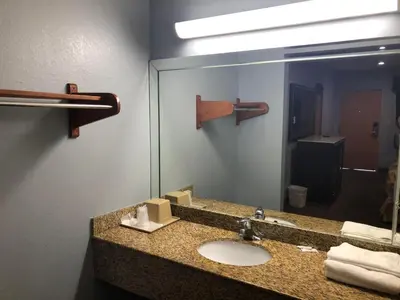 a bathroom with a sink and a mirror at La Mirage Inn LAX Airport in Los Angeles
