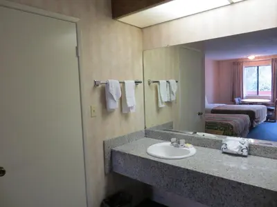 a bathroom with a sink and a mirror at Days Inn by Wyndham Anaheim West in Anaheim