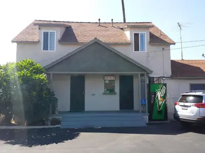 a house with a car parked in front of it at New Kansan Motel in Rancho Cucamonga