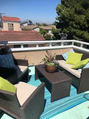 a patio with wicker chairs and tables on a roof at 