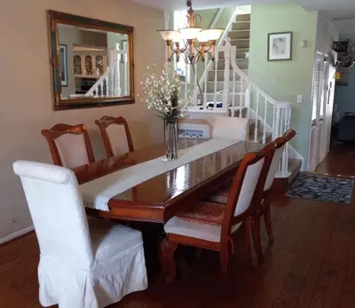 a dining room table with chairs and a mirror at 