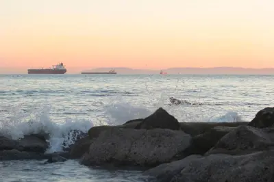 a person swimming in the ocean with a ship in the distance at 