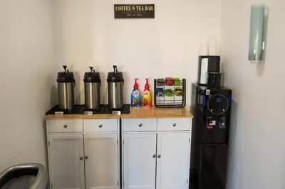 a kitchen with a counter and a black refrigerator at Capri Suites Anaheim in Anaheim