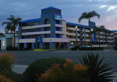 a large building with a parking lot in front of it at Capri Suites Anaheim in Anaheim