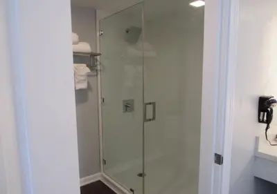 a shower with a glass door in a bathroom at Capri Suites Anaheim in Anaheim