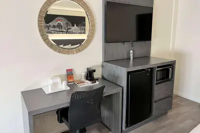 a desk with a television and a chair in a room at Ramada by Wyndham Anaheim Convention Center in Anaheim