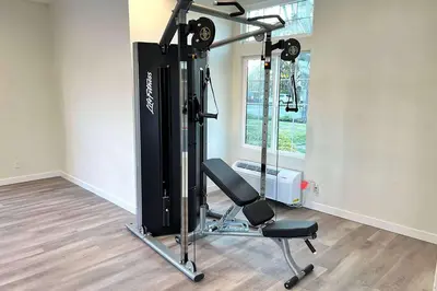 a room with a gym with a treadmill and a chair at Ramada by Wyndham Anaheim Convention Center in Anaheim