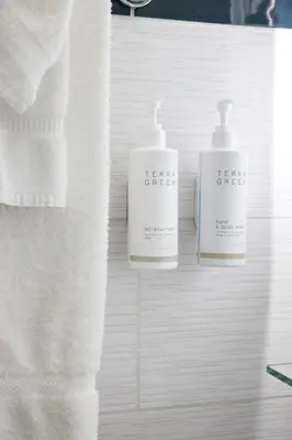 two bottles of detergent sitting on a bathroom counter at Hotel Carmel Santa Monica in Los Angeles