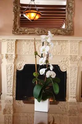 a white vase with white flowers on a table at Hotel Carmel Santa Monica in Los Angeles