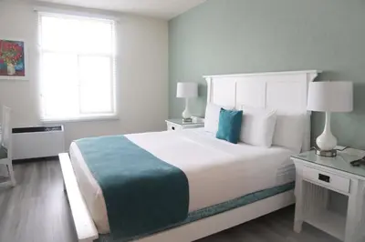 a bedroom with a large white bed and a window at Hotel Carmel Santa Monica in Los Angeles