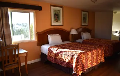a hotel room with two beds and a window at Valley Hotel in Rosemead